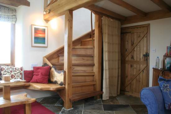 Handcrafted oak staircase leading up to our mezzanine bedroom with oak four poster bed